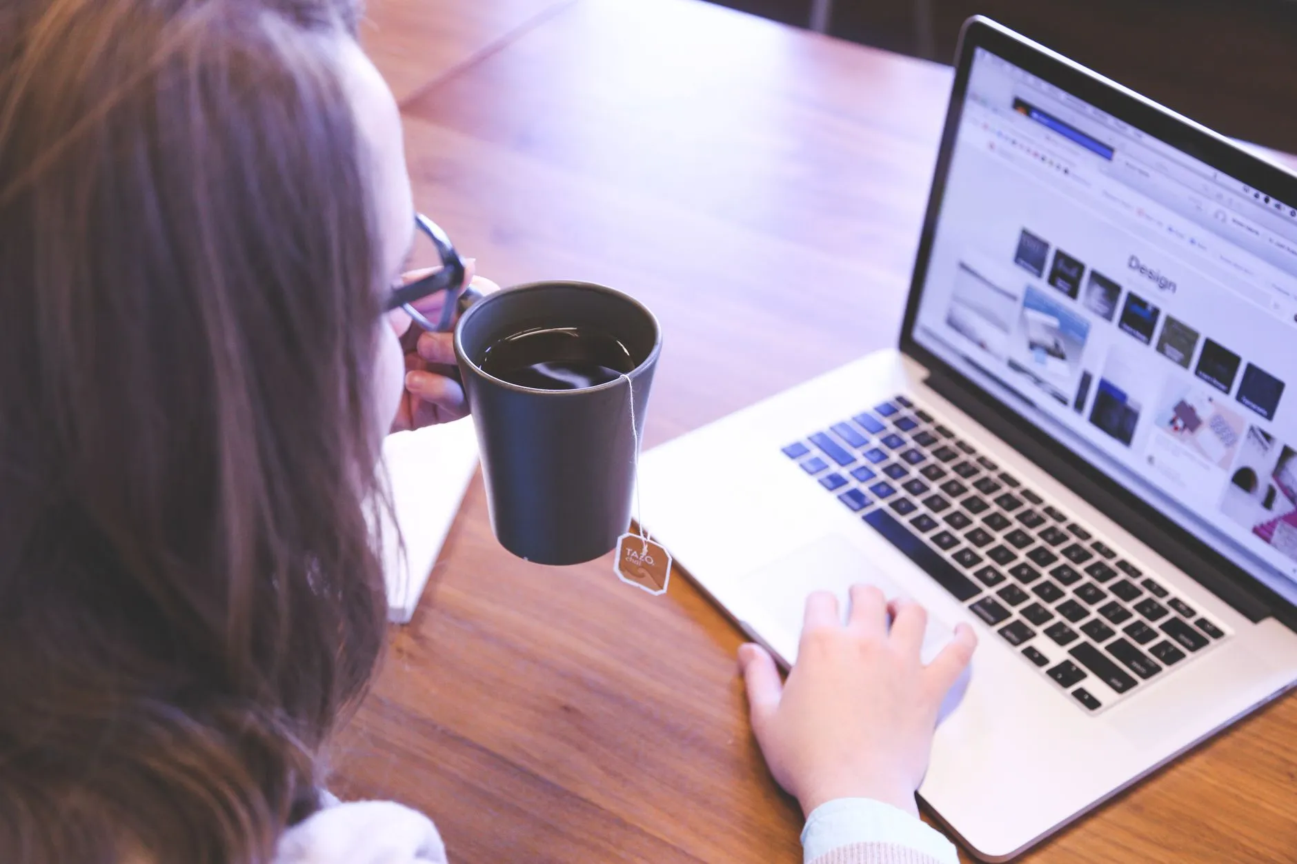 Someone working at a laptop with a mug of coffee